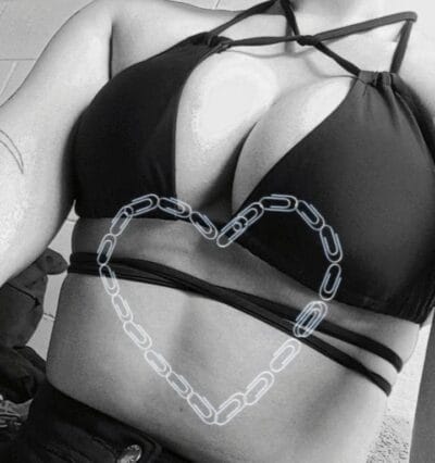 Woman in a black bikini top with a chain-link heart outline drawn over her midsection in grayscale.